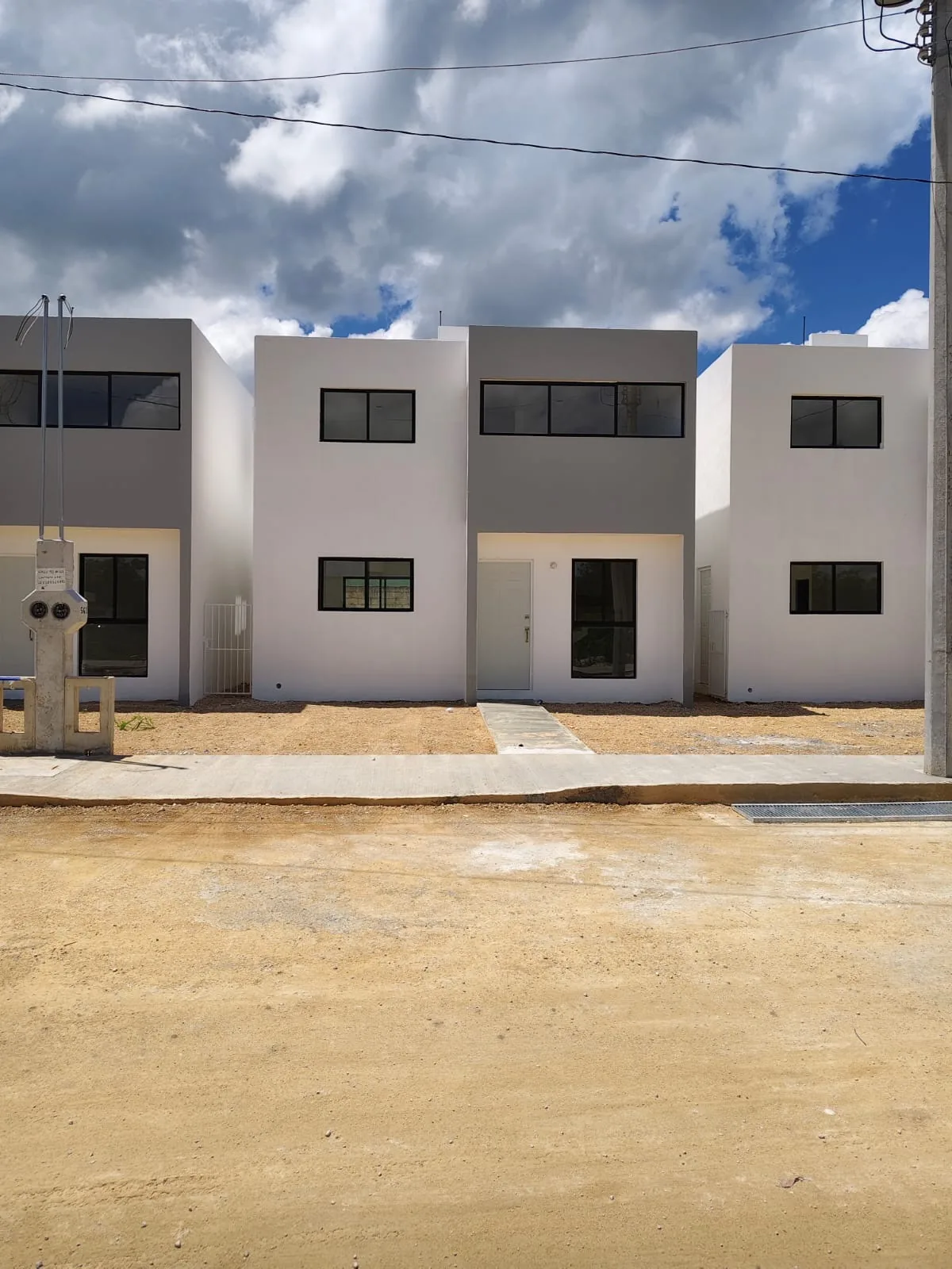 Vista frontal de las casas desde la calle, con el andador de acceso escobillado