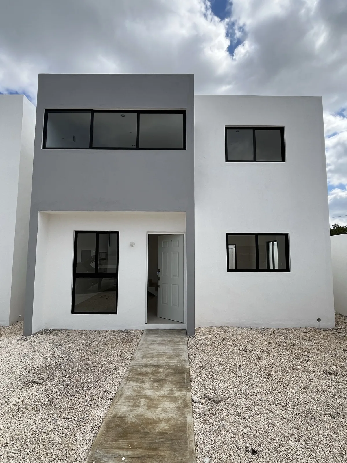 Fachada posterior de las casas, con los patios delimitados y el acabado en gris y blanco