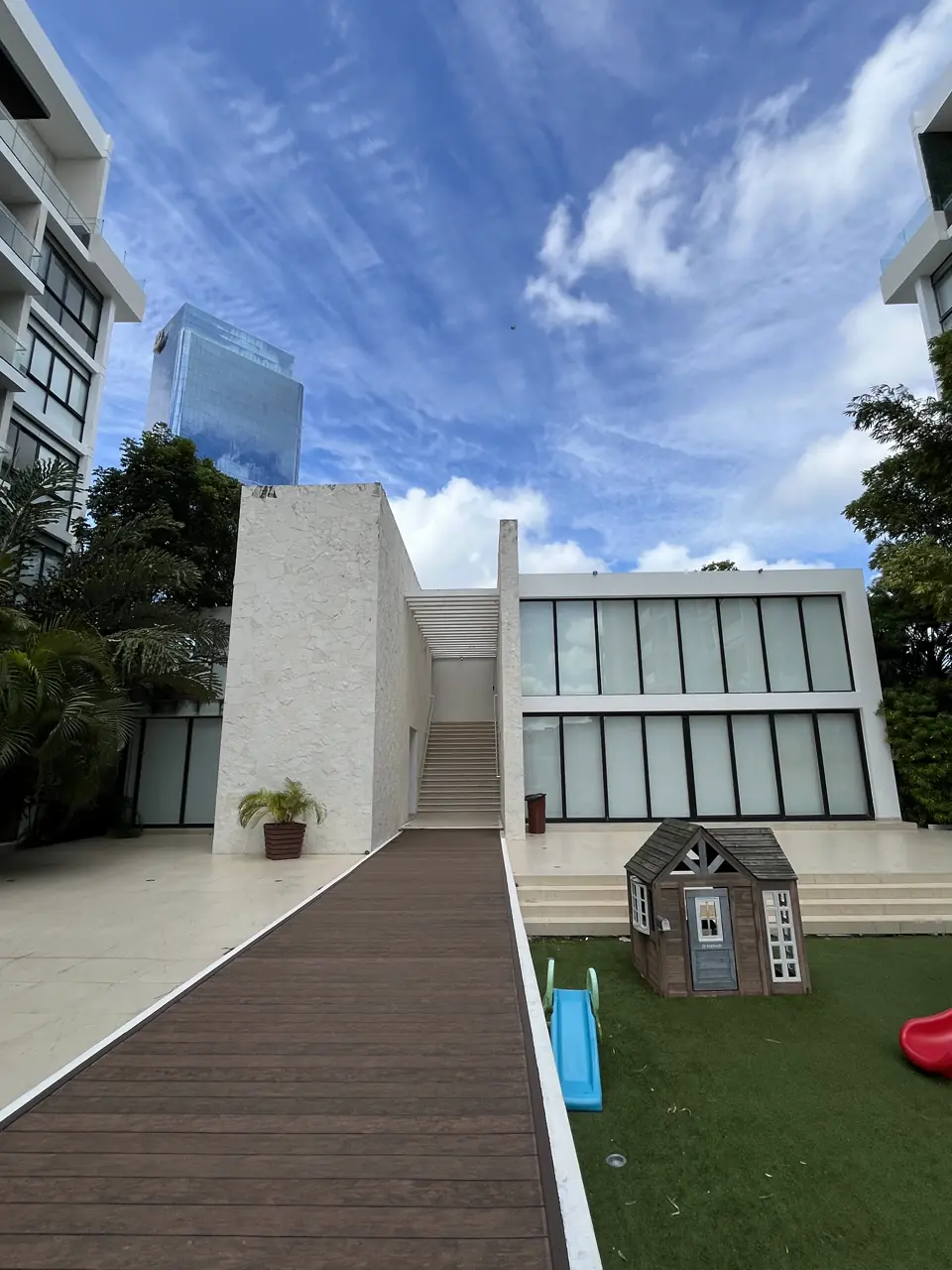 Casa club de dos niveles con escalinata de acceso y andador de madera