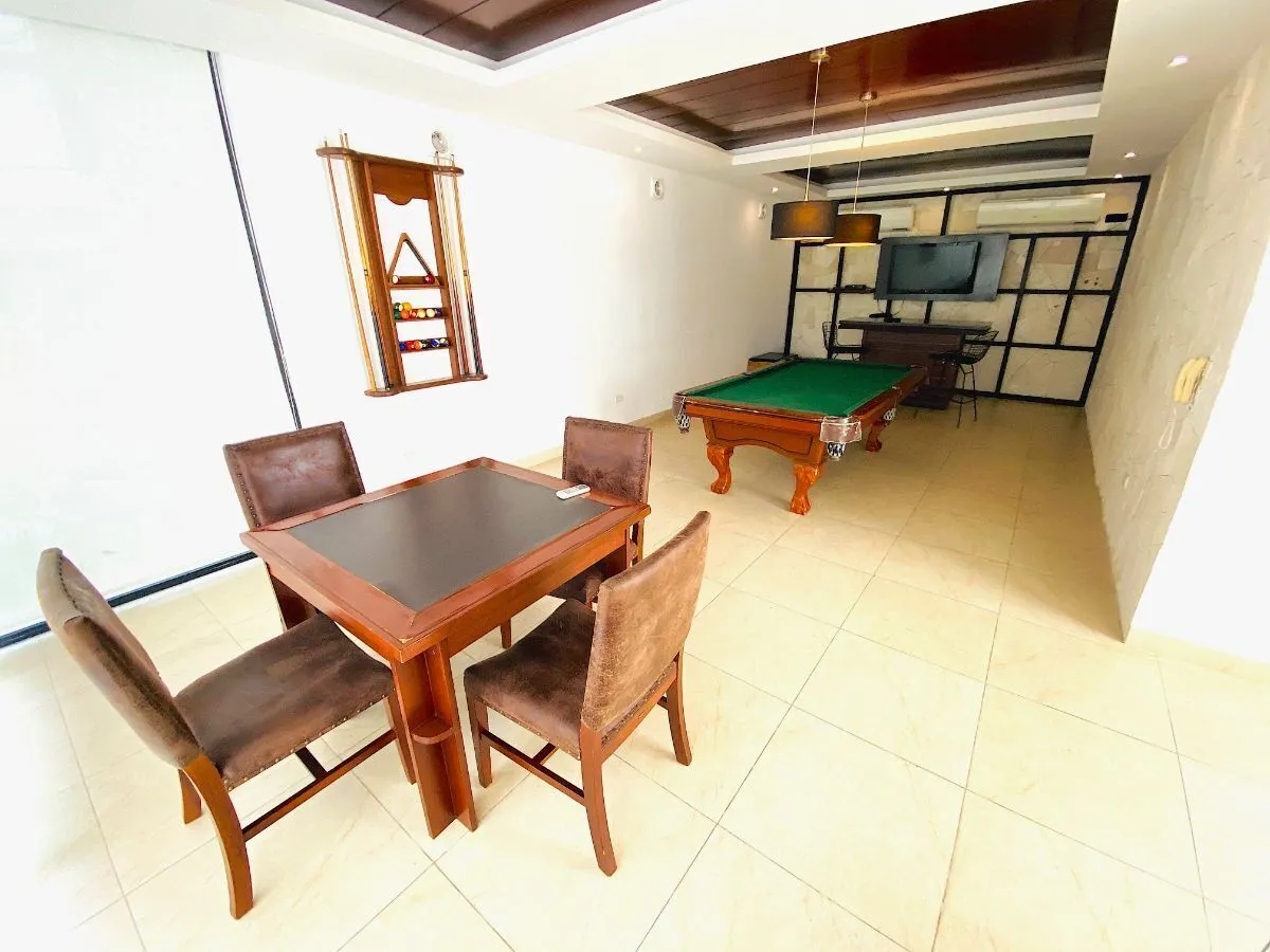 Salón de juegos con mesa de billar, mesa de cartas y pantalla