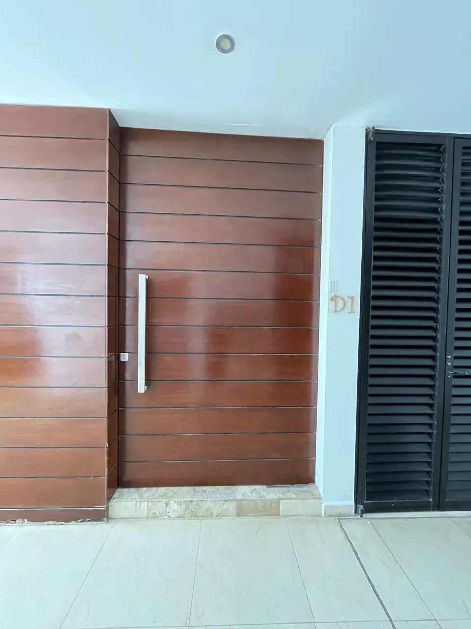 Puerta de acceso de madera del departamento D1, con entrada directa desde el andador