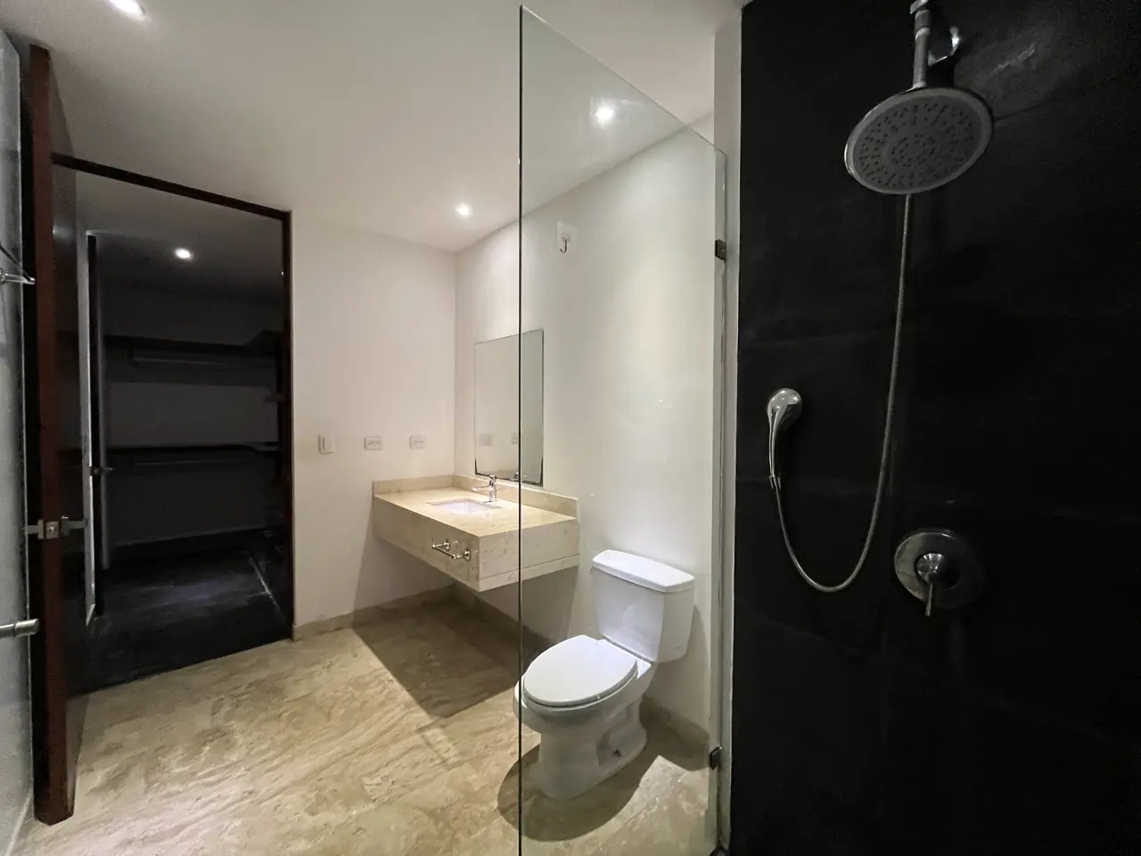 Baño secundario con muro de pizarra negra y regadera de vidrio