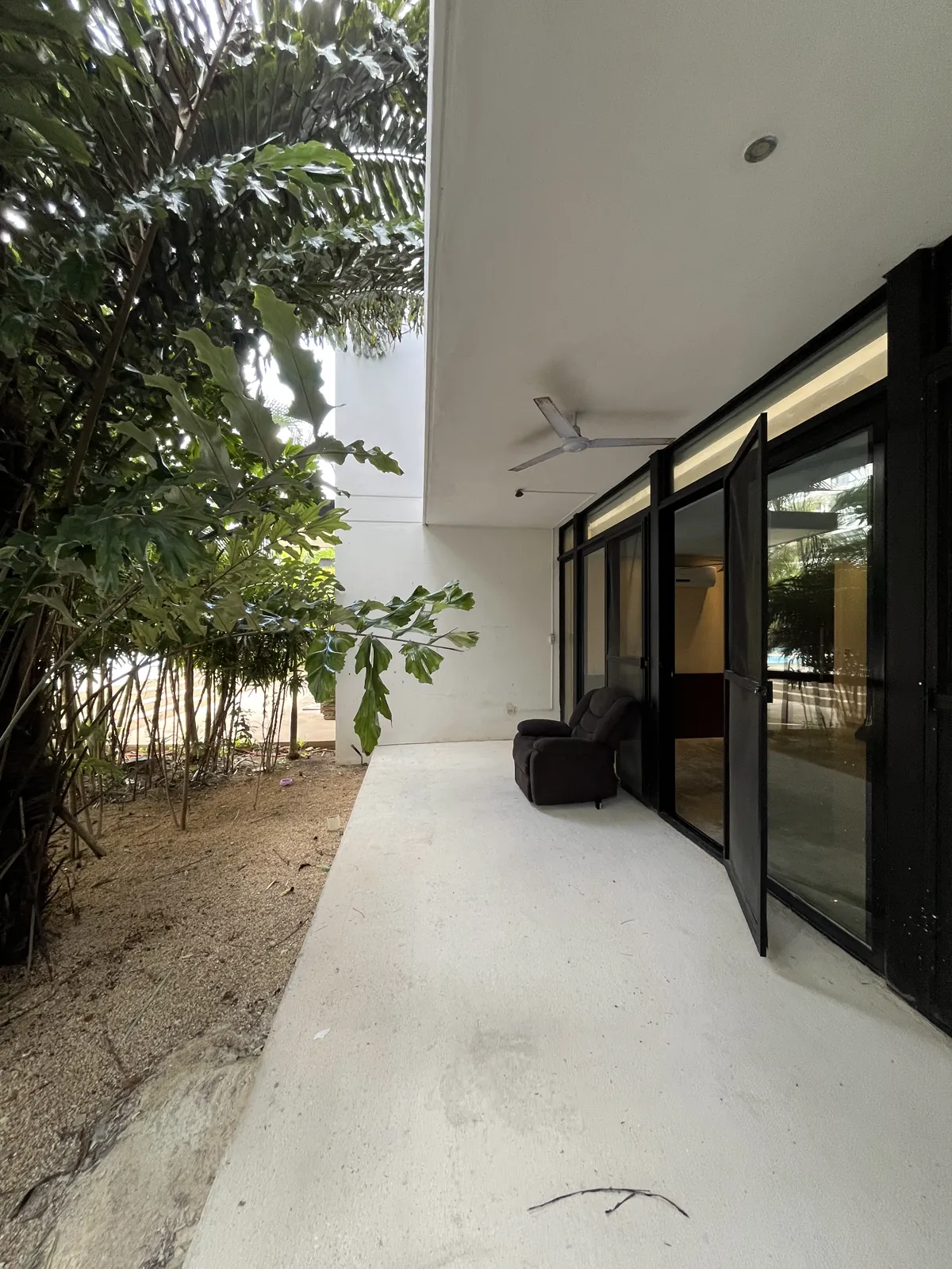 Terraza de la planta baja con el jardín privado y la vegetación madura a un costado