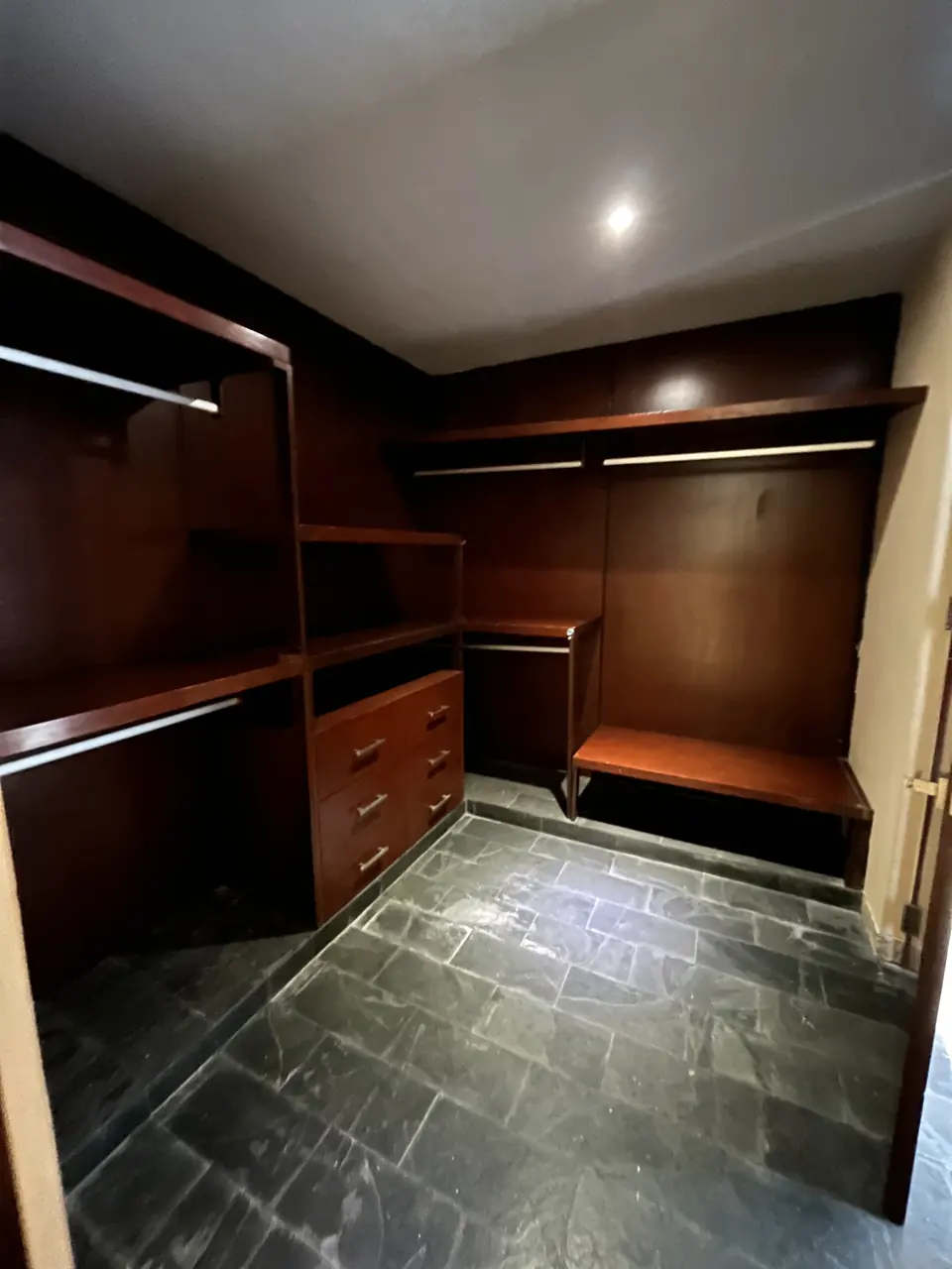 Vestidor caminable en madera con doble barra, entrepaños y piso de pizarra